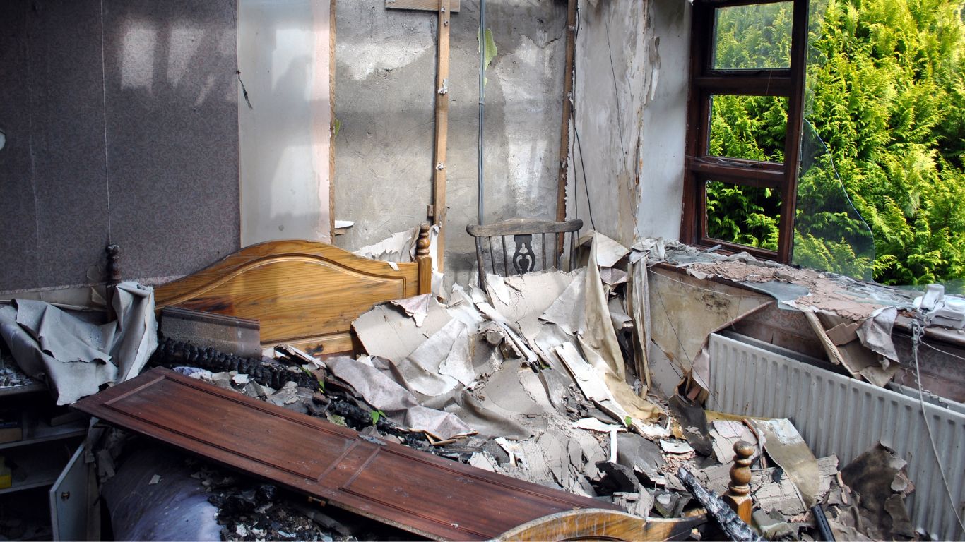Heavily damaged bedroom interior after a house fire awaiting fire damage restoration in Stamford.