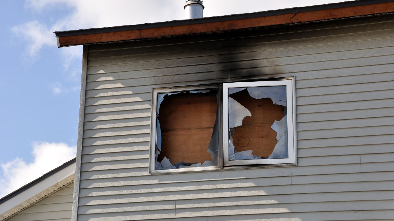 Broken window from fire damage requiring fire damage restoration in Boston.