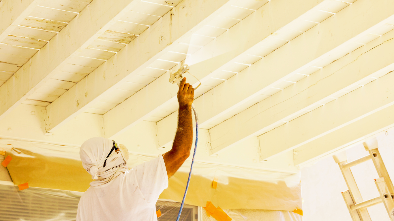 Breathe Easier with Advanced Dehumidification Solutions for Your Home A professional painter in protective gear sprays a wooden ceiling, showcasing the importance of proper painting techniques for home maintenance and aesthetics.