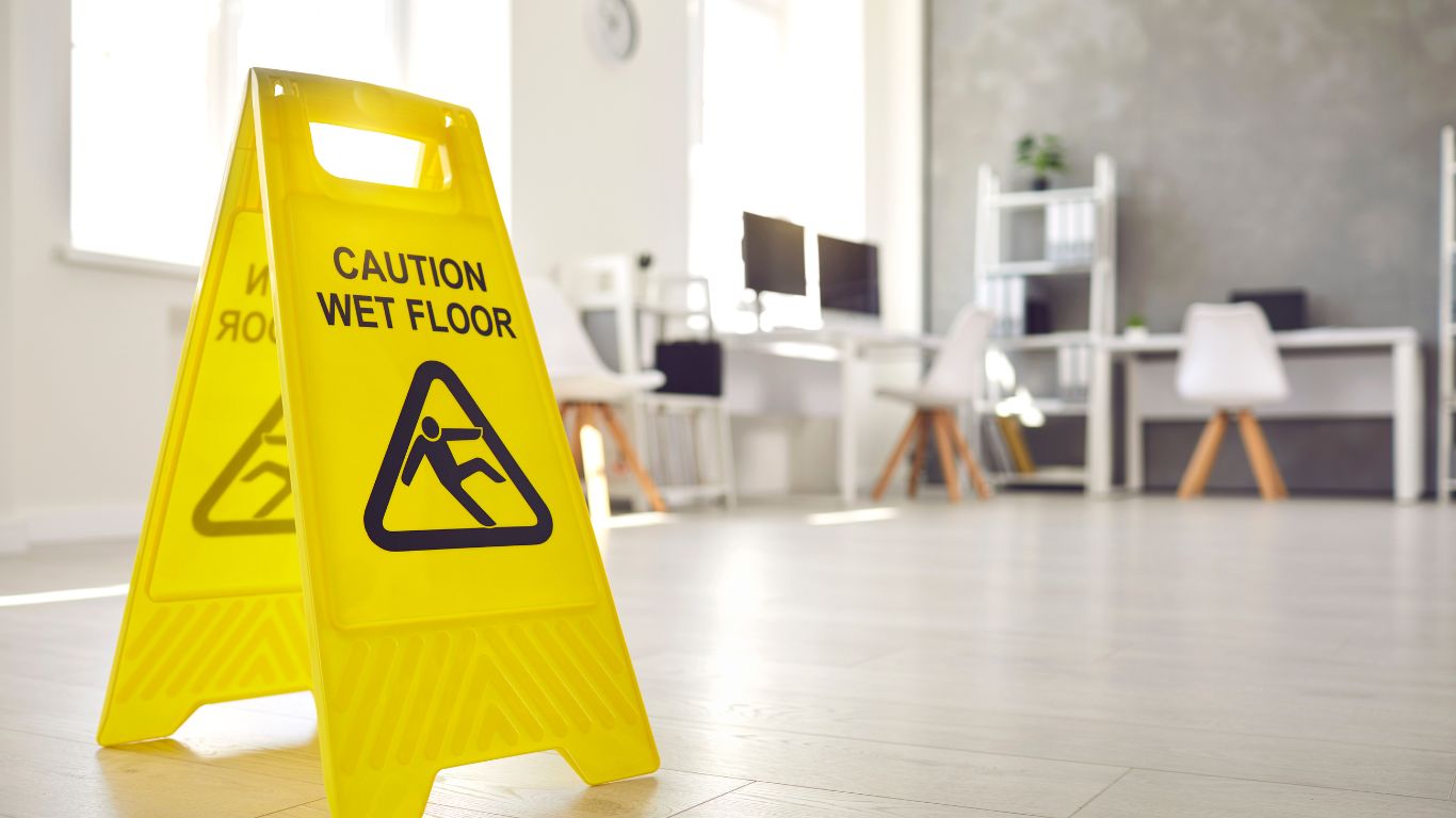 Keep Your Business Running with Top Tier Commercial Restoration Services in Minneapolis Wet floor caution sign in office building after water incident requiring commercial restoration services.