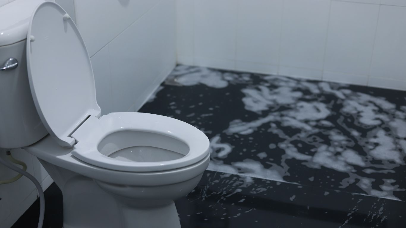 Overflowed bathroom toilet with contaminated water on floor requiring professional sewage cleanup